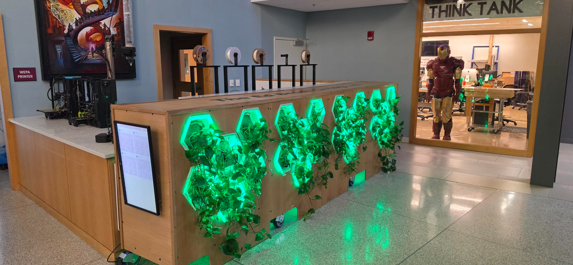 Greenwall, a wall-mounted hydroponic planter with backlit hexagonal plant cells glowing green, installed at the entrance to the BSU Think Tank