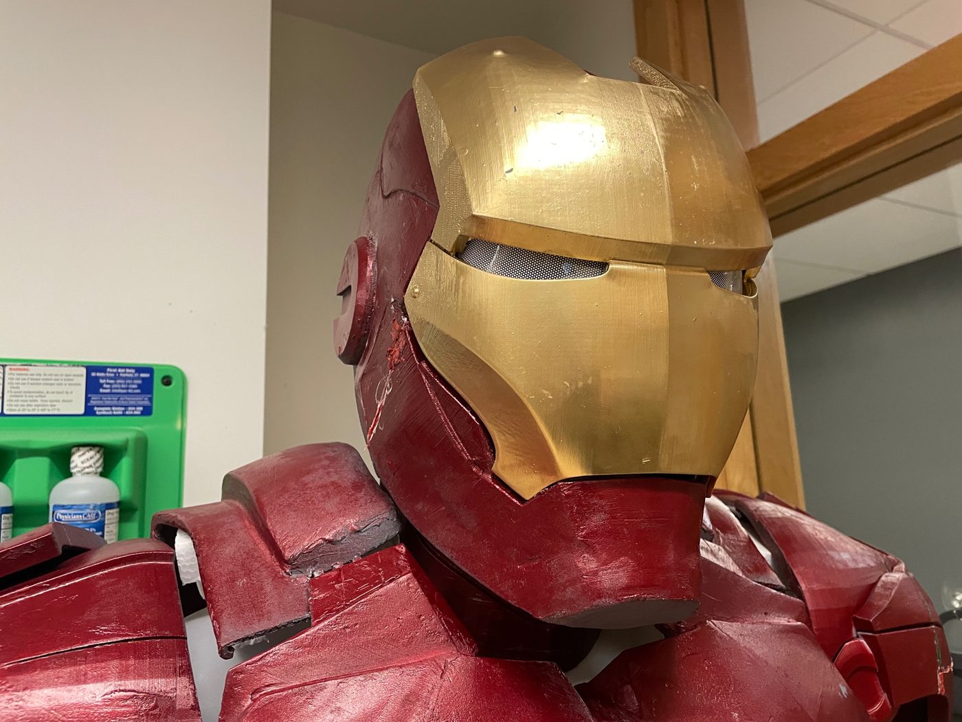 Close up of the suit's gold and red helmet with mesh eye openings